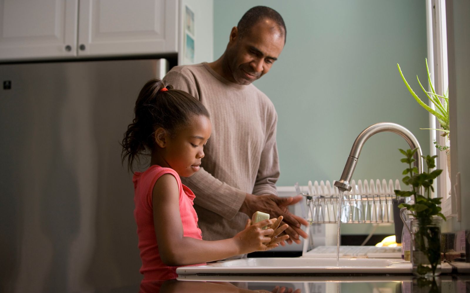 father and daughter washing hands