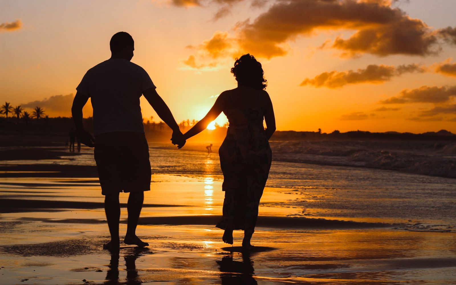 Coupe holding hands on beach