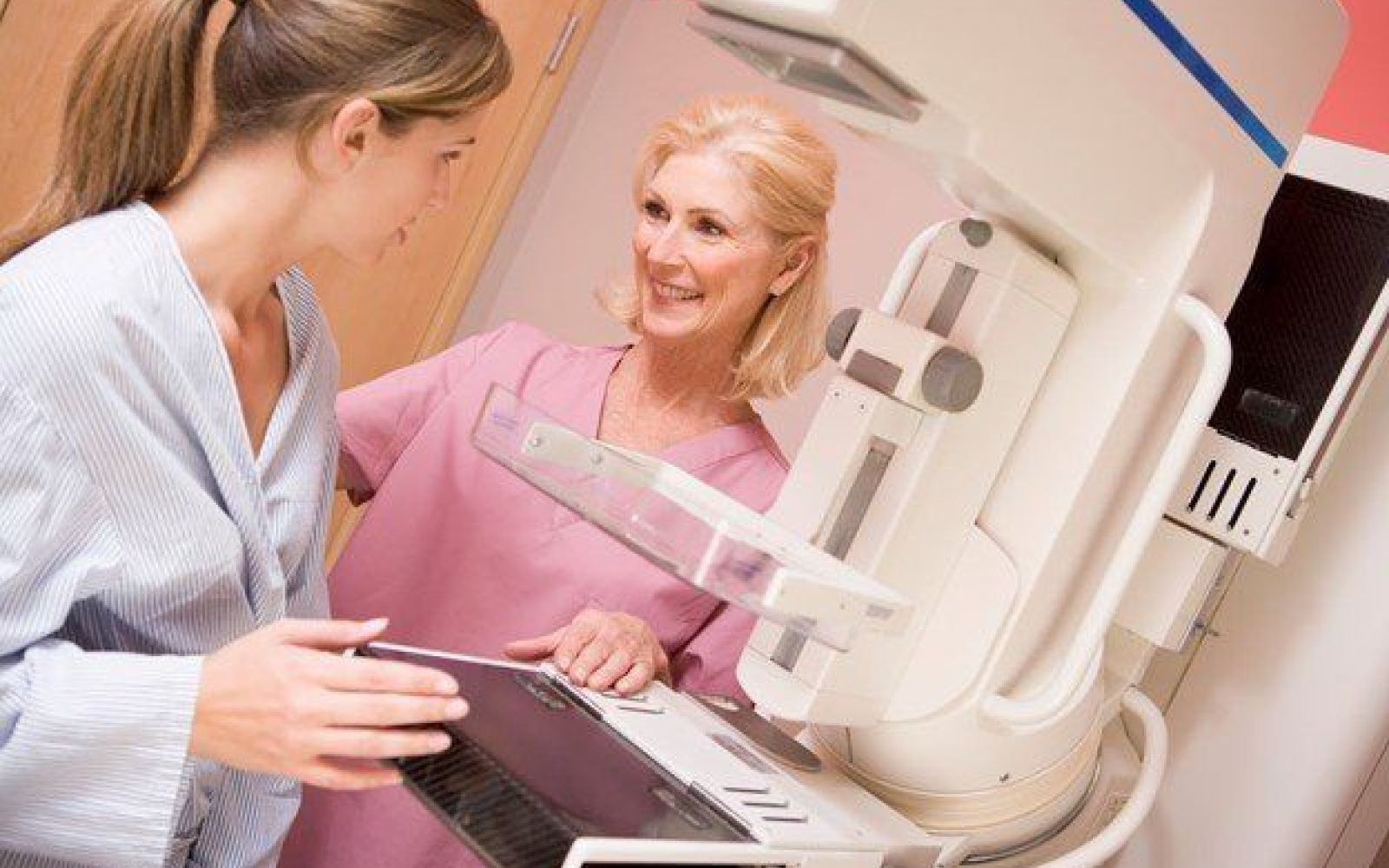 nurse prepping woman for mammogram