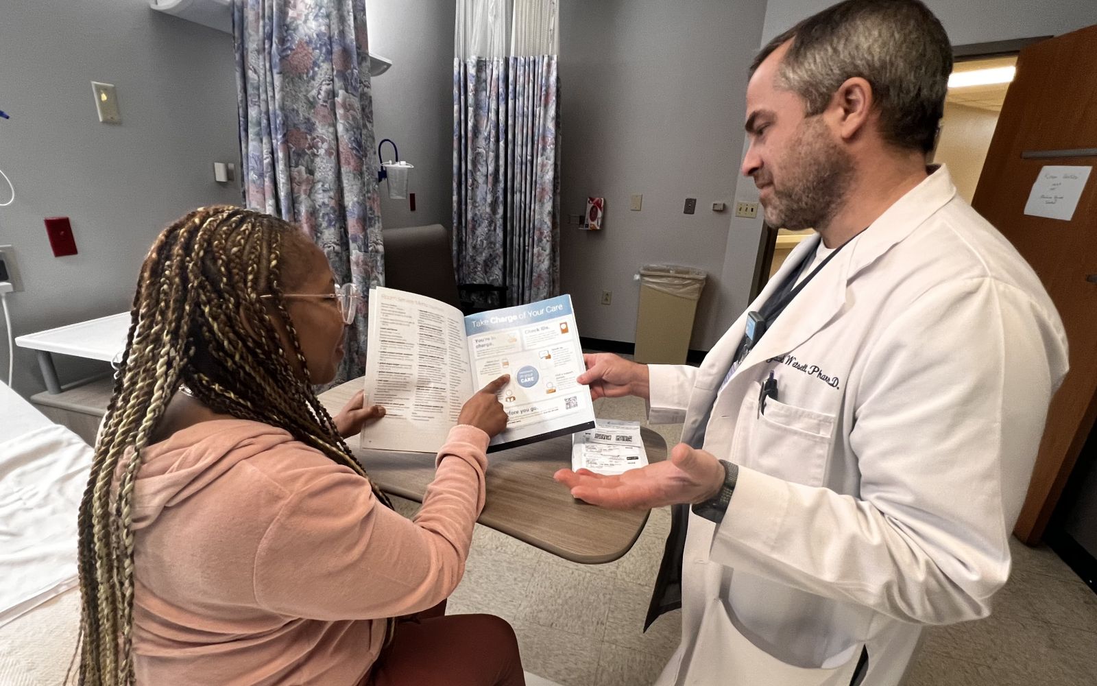 Jacob Wetsell, PharmD, BCPS reviews medication with a patient at Nashville General