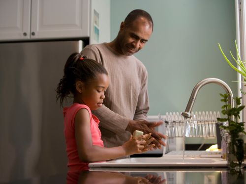 father and daughter washing hands