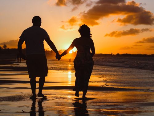 Coupe holding hands on beach