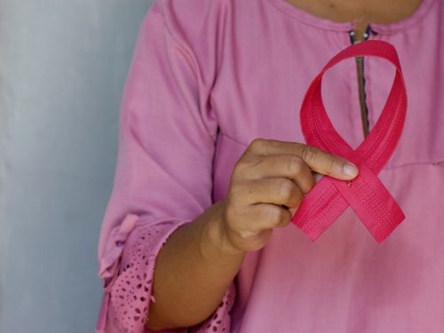 Woman holding a pink ribbon as an awareness of Breast Cancer Day, October, 1, 2020.