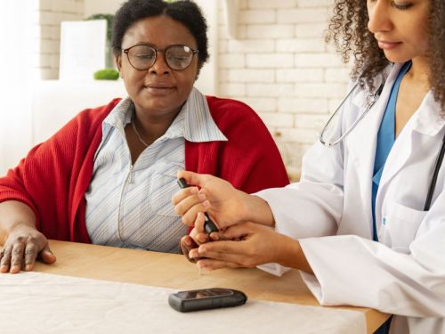 nurse checking blood sugar of elderly woman