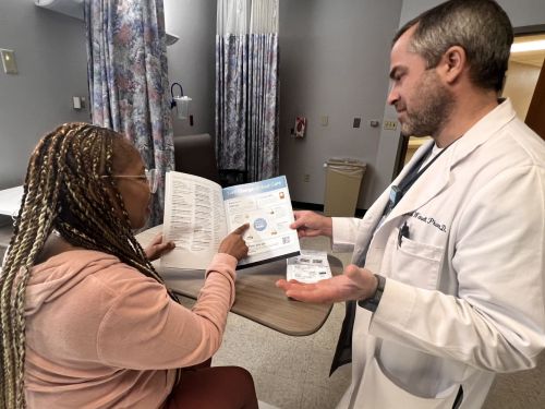  Jacob Wetsell, PharmD, BCPS reviews medication with a patient.