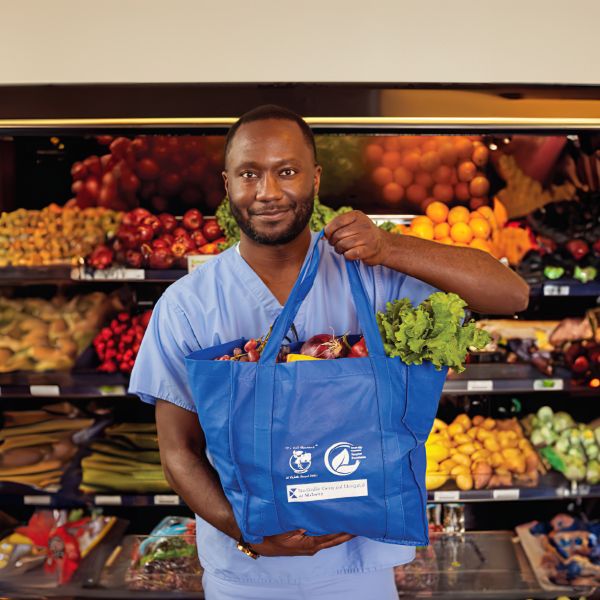 Photo of Food Program staff with tote bag full of vegetables