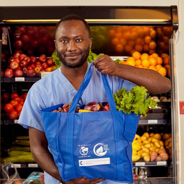 Man holding food tote in NGH Food Pharmacy