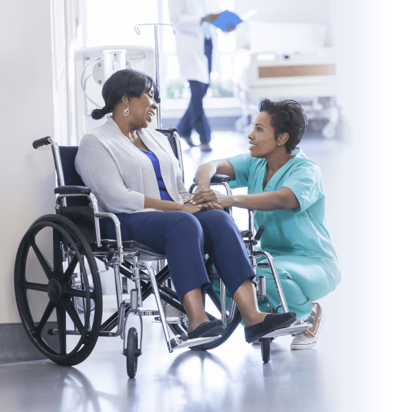 nurse helping older woman in wheelchair