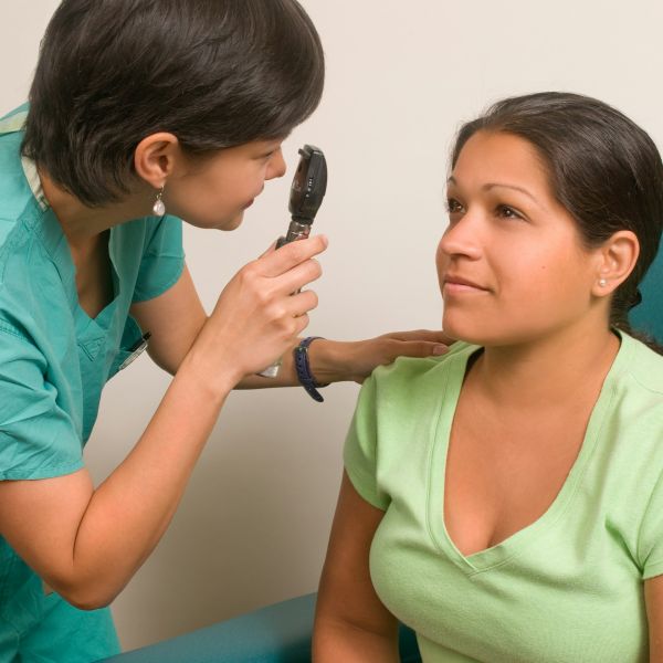  An ophthalmologist examining a patient's eye with an ophthalmoscope