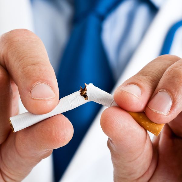 Doctor breaking a cigarette — smoking cessation visual